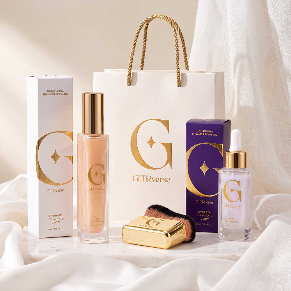 GLTRverse Celestial Glow Duo set, warm gold Halo and pearl-violet Stardust shimmer body oils with the gold brush, white and violet boxes and gift bag